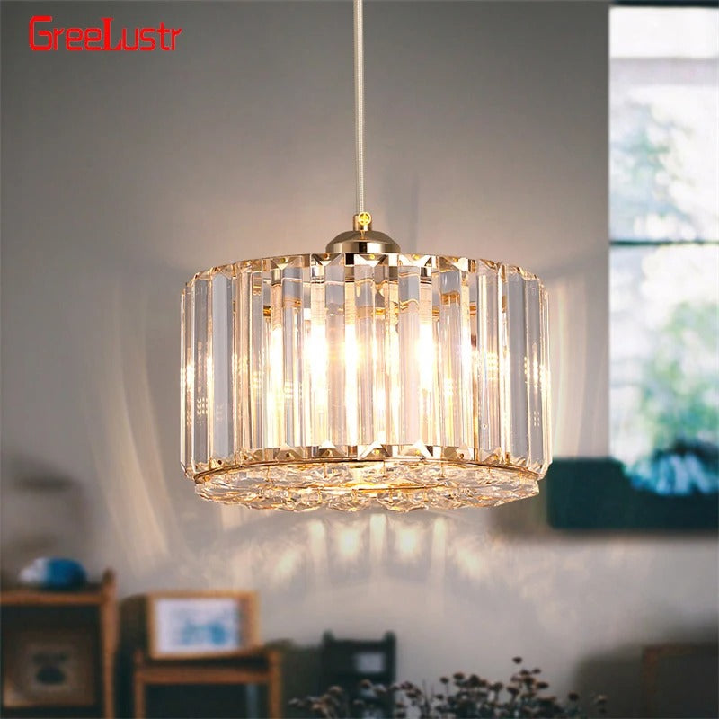 Modern gold crystal pendant light hanging over kitchen island